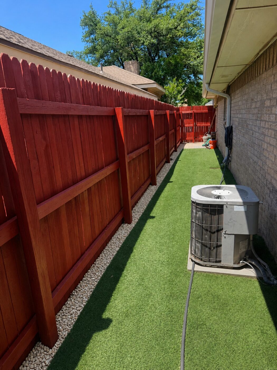 Fresh wood fence with artificial turf and rock